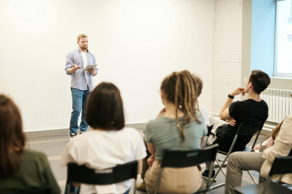 Man Wearing Gray Dress Shirt and Blue Jeans Teaching First Aid in Campbelltown